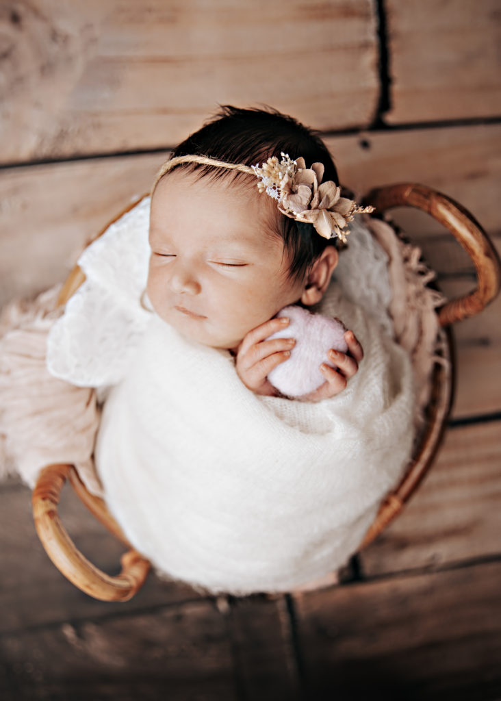 Nouveau-né emmailloté avec bandeau dans un panier, photo bébé studio Provence