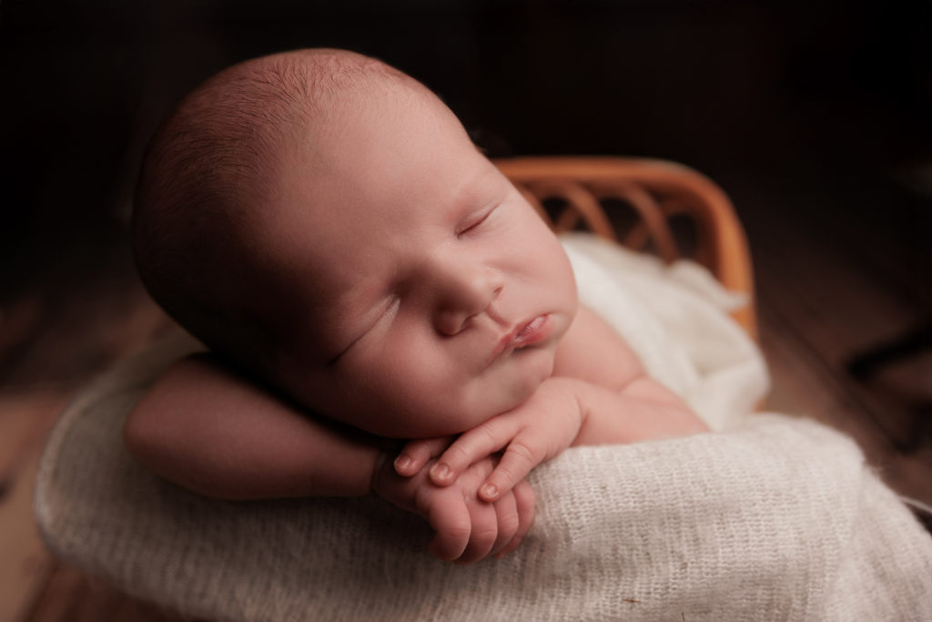 Nouveau-né endormi en gros plan sur fond clair, photo naissance studio Provence