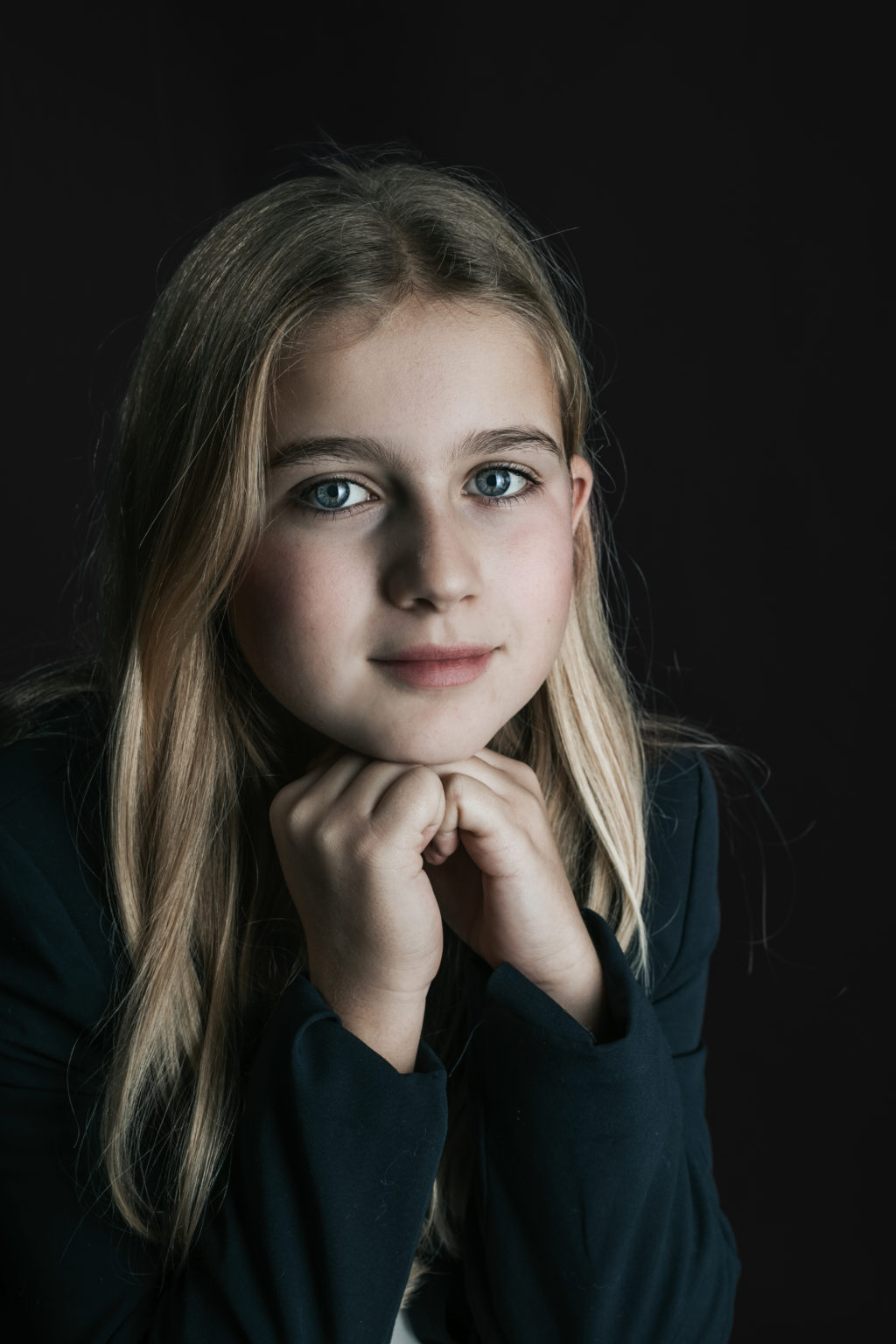 Portrait d'une adolescente au regard intense sur fond noir