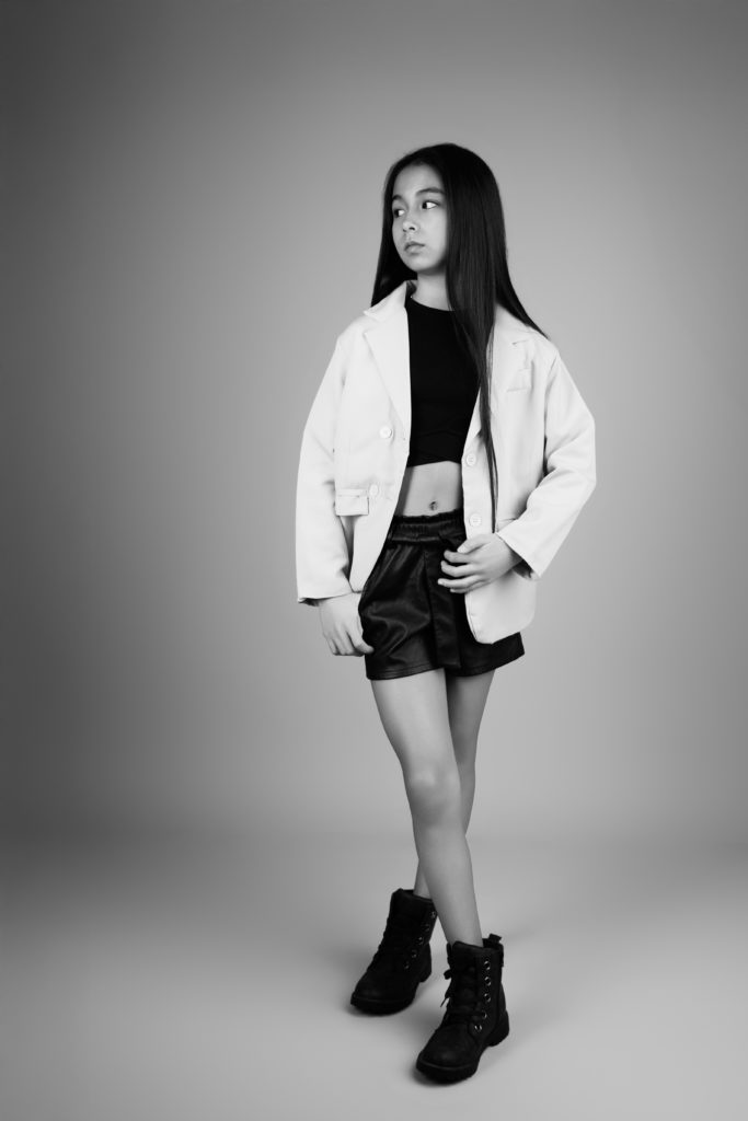 Jeune fille posant en studio, noir et blanc, style affirmé