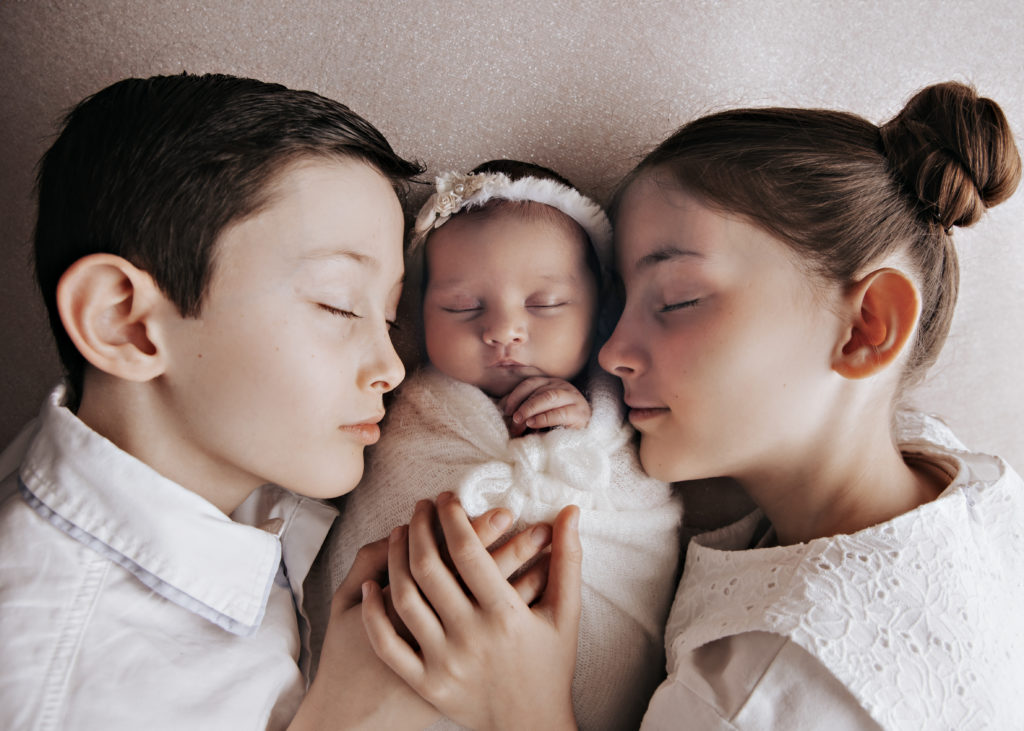 Frère et sœur entourant un nouveau-né, photo naissance en fratrie en studio à Rognonas près d’Avignon