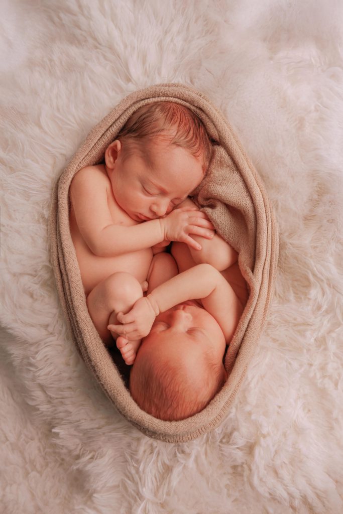 Nouveau-né en position fœtale dans un nid doux, photographie artistique bébé studio Provence