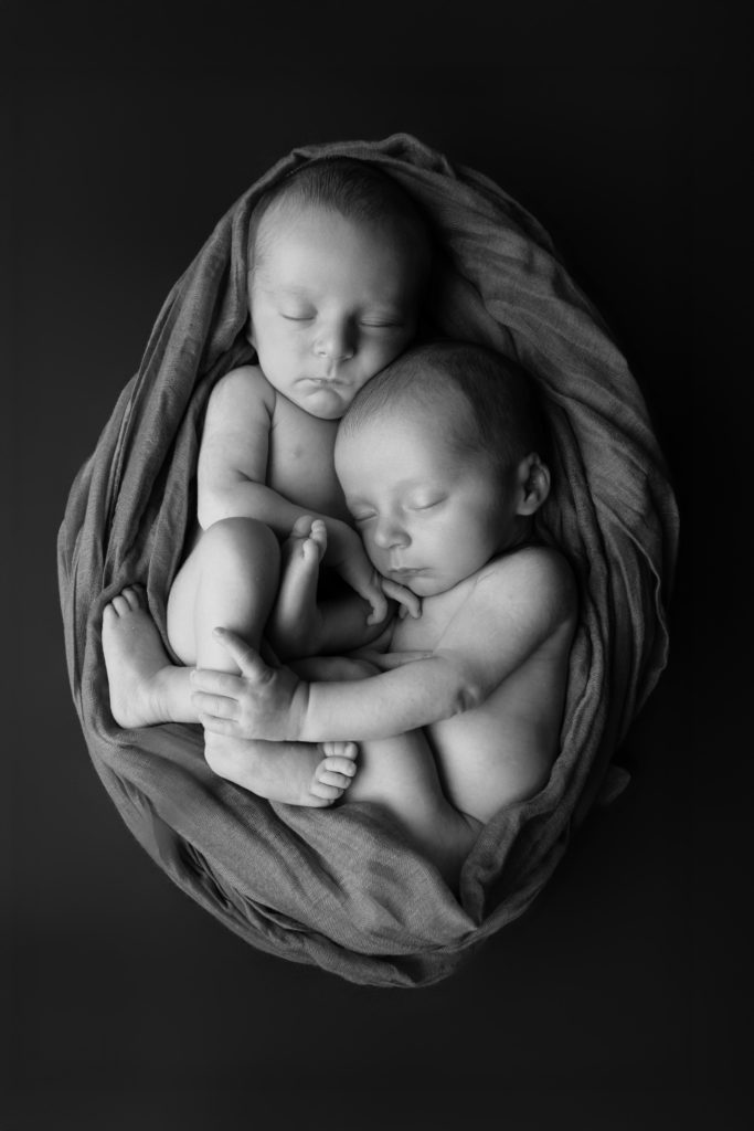 Deux nouveau-nés endormis ensemble en noir et blanc, photo jumeaux studio Provence