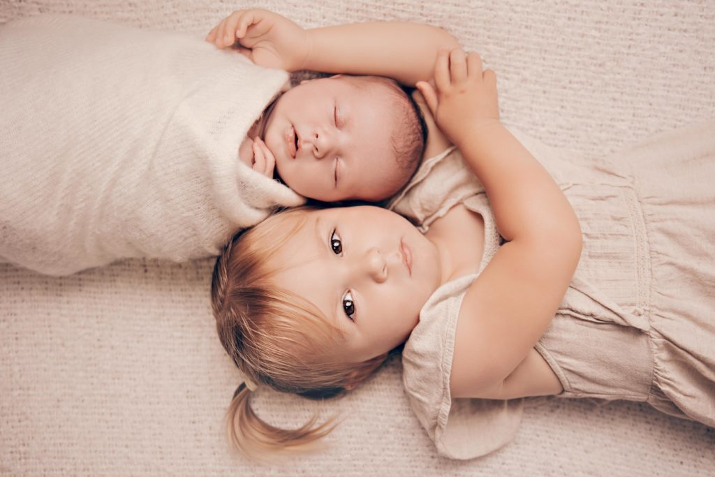 Bébé et enfant allongés ensemble, photo naissance en studio à Rognonas près d’Avignon