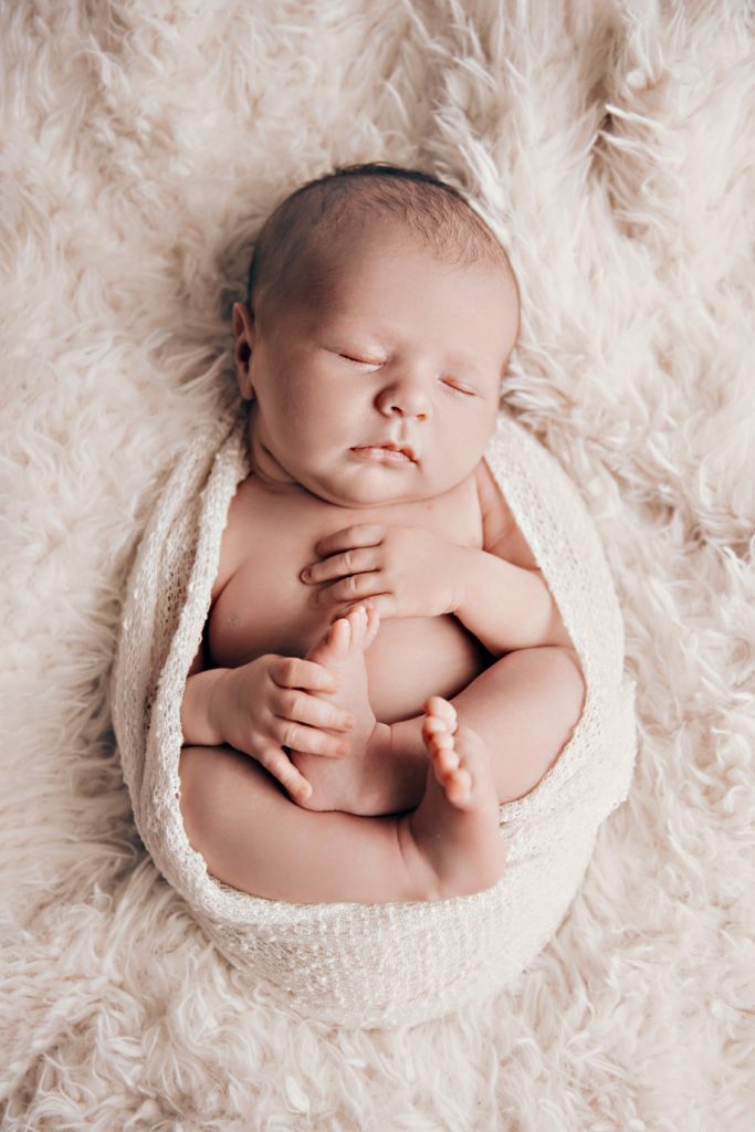 Nouveau-né emmailloté sur fond clair, portrait bébé en studio photographique près d’Avignon