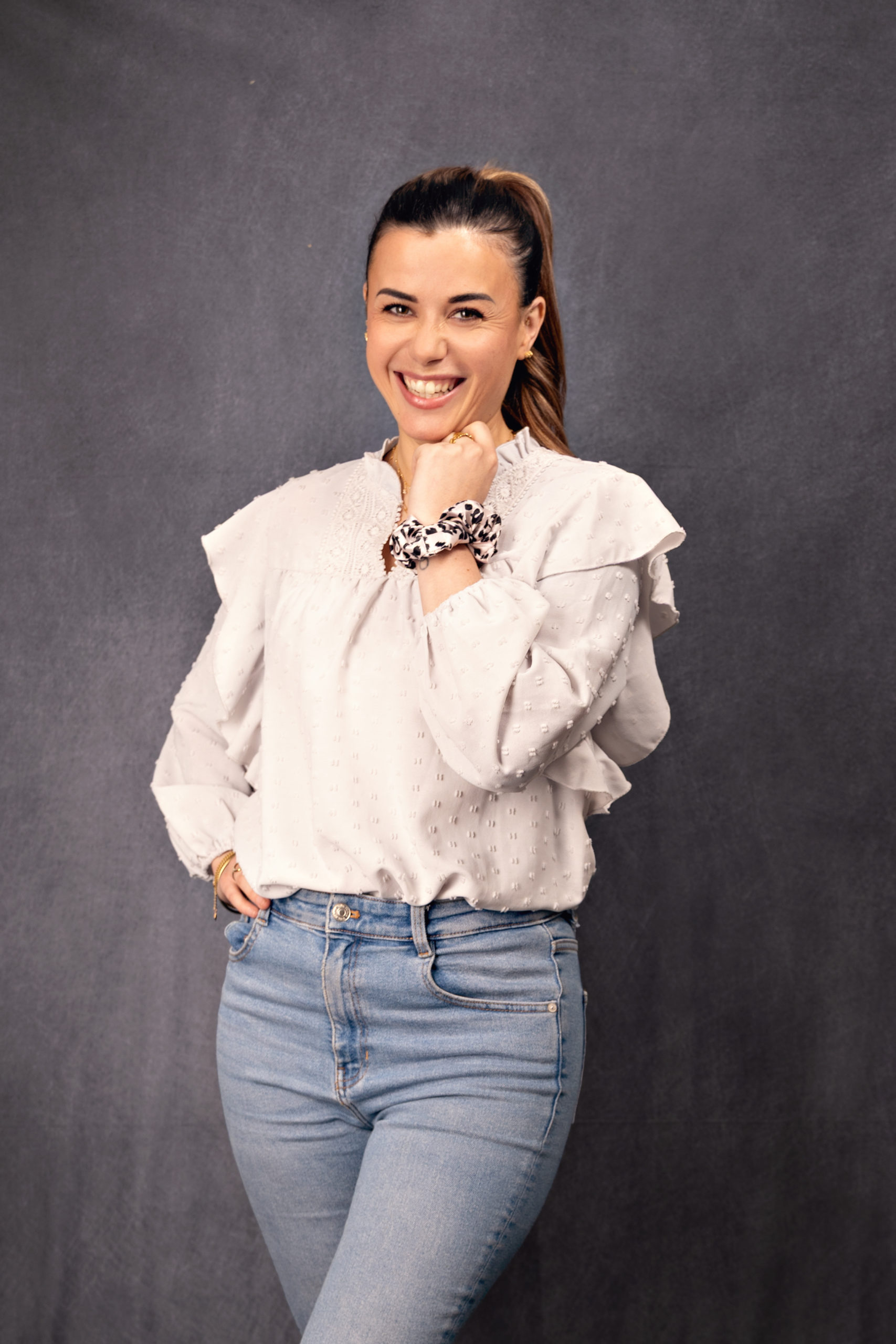 Portrait professionnel d’une femme souriante en studio sur fond gris, photographie réalisée à Rognonas